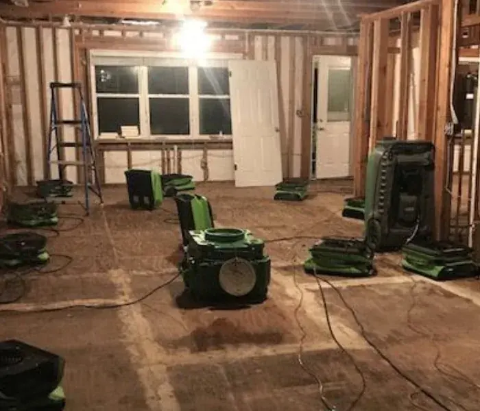 A dehumidifier running in a dried-out room in a Coachella Valley home